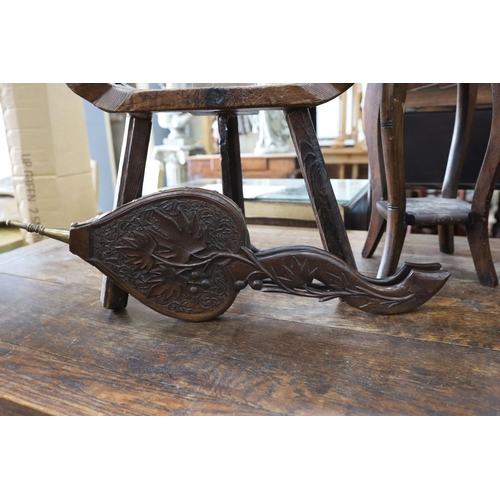 1132 - A small child's oak rocking chair, a pair of carved wood bellows and two caned tables