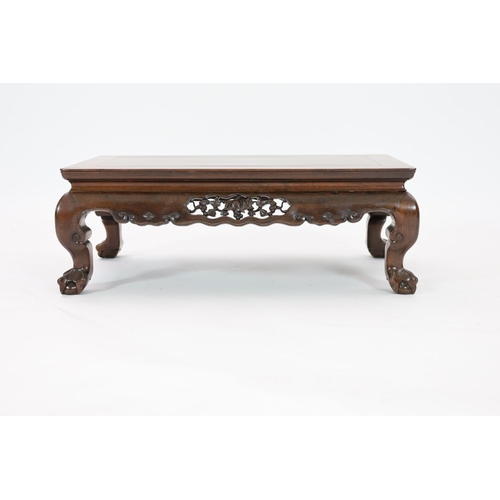 1185 - A Chinese hongmu Kang table, 19th century,the panelled rectangular top above a fruiting vine carved ... 