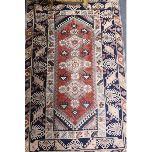 1219 - A Caucasian red ground rug and a Bokhara runner, rug 180 x 120 cms