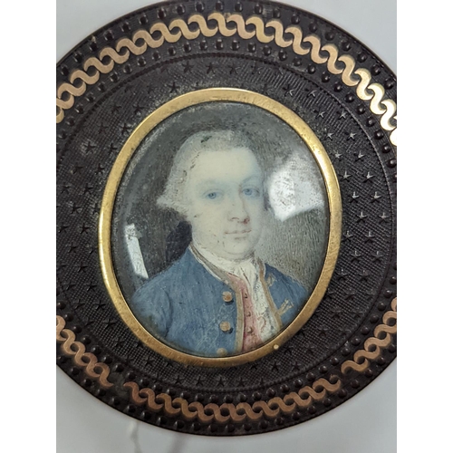 1557 - A 19th century pressed bois durci and gilt metal snuff box with painted miniature portrait of a gent... 