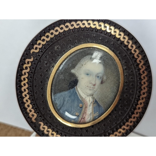 1557 - A 19th century pressed bois durci and gilt metal snuff box with painted miniature portrait of a gent... 