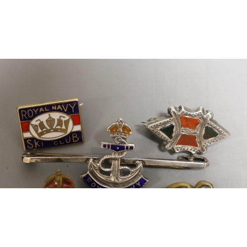 1558 - Four military badges: A Royal Navy badge and ski club badge, South Africa badge and another.... 