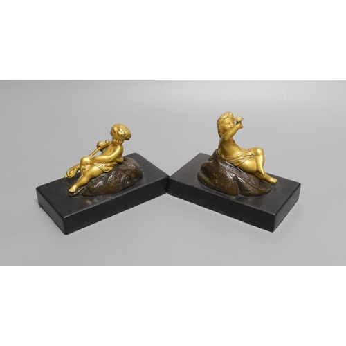 1566 - A pair of ormolu putto paperweights on black marble bases,13 cms wide.