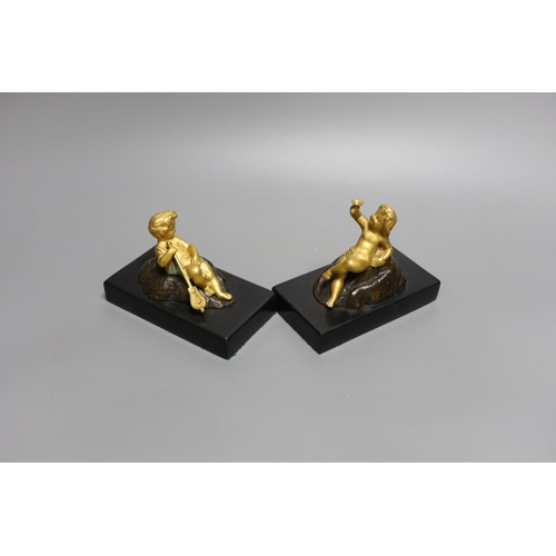 1566 - A pair of ormolu putto paperweights on black marble bases,13 cms wide.