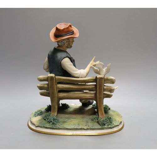 1609 - A Capodimonte figure of a tramp sat on a bench feeding doves 27cm