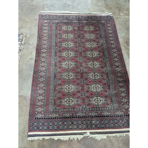 42 - A Tekke Bokhara red ground rug, woven with rows of elephant feet, 180 x 126cm