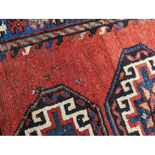 24 - A Caucasian red ground rug, 210 x 110cm