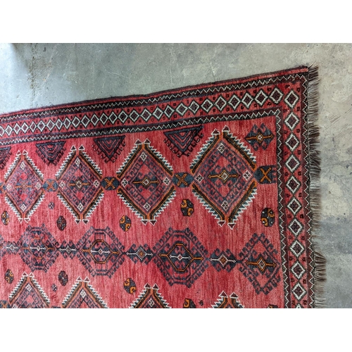 58 - A Caucasian style red ground rug, 255 x 167cm