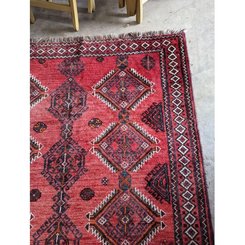 58 - A Caucasian style red ground rug, 255 x 167cm