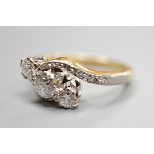 932 - A yellow metal and three stone diamond set crossover ring, with diamond set shoulders, size I, gross... 