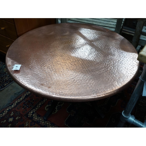 1041 - A circular hammered copper and wrought iron low table, diameter 88cm height 49cm