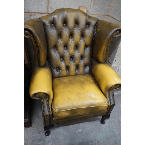 1111 - A Victorian style green leather wing armchair, width 82cm depth 76cm height 100cm