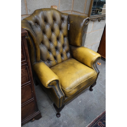 1111 - A Victorian style green leather wing armchair, width 82cm depth 76cm height 100cm