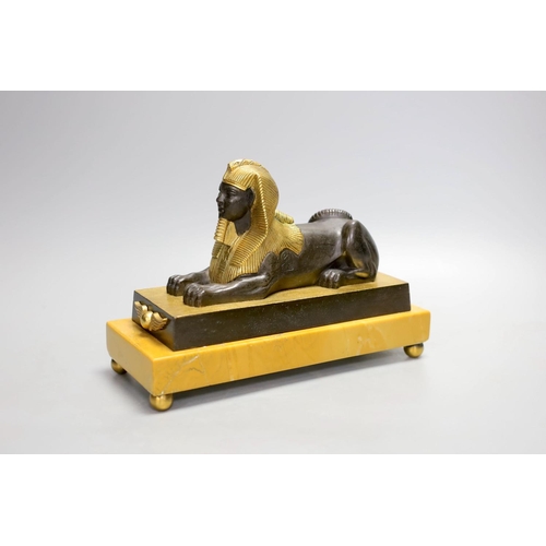 1425 - A parcel gilt bronze model of a sphinx on a Siena marble base - 22cm long