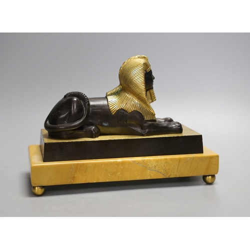 1425 - A parcel gilt bronze model of a sphinx on a Siena marble base - 22cm long