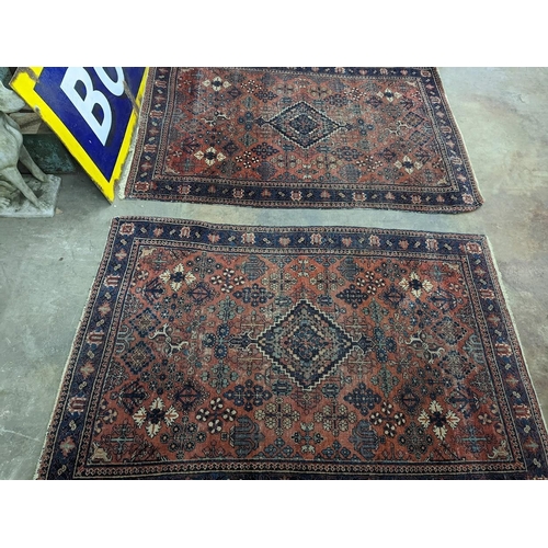 1073 - A pair of Caucasian red ground rugs, 200 x 134cm