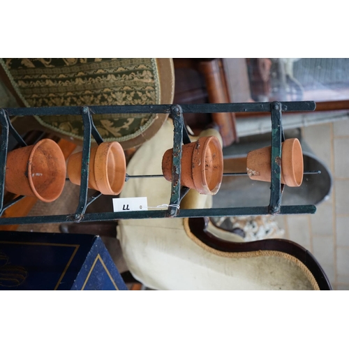 1077 - A wrought iron six tier pot stand, together with six terracotta pots, height 143cm