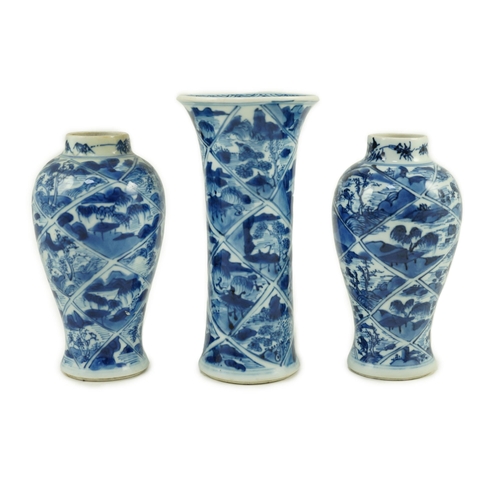 148 - A garniture of three Chinese blue and white vases, Kangxi period, each painted with landscape vignet... 