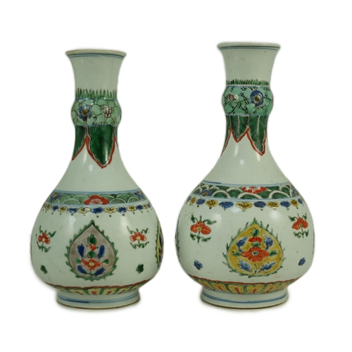 159 - A near pair of Chinese famille verte garlic-neck vases, Kangxi period, each painted with flowers wit... 