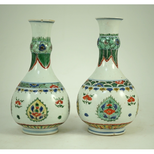 159 - A near pair of Chinese famille verte garlic-neck vases, Kangxi period, each painted with flowers wit... 