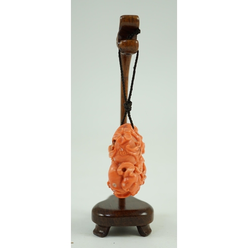 202 - A good Chinese coral fruit and bats pendant, 19th century, carved in high relief and open work wit... 