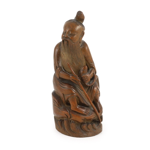 210 - A Chinese bamboo figure of a seated fisherman, 19th century, Holding a rod in his right hand and a f... 