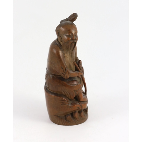 210 - A Chinese bamboo figure of a seated fisherman, 19th century, Holding a rod in his right hand and a f... 