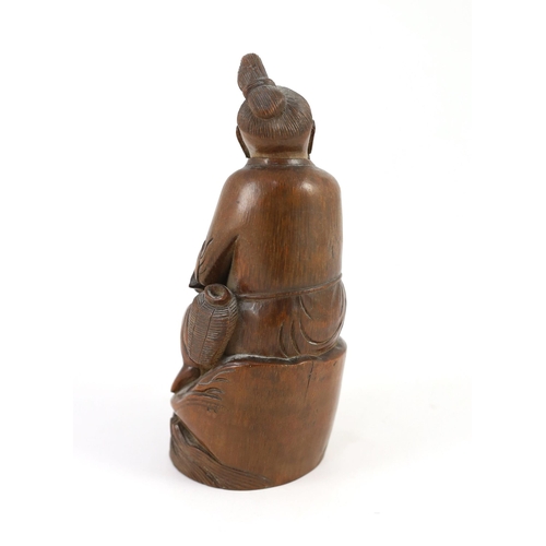 210 - A Chinese bamboo figure of a seated fisherman, 19th century, Holding a rod in his right hand and a f... 