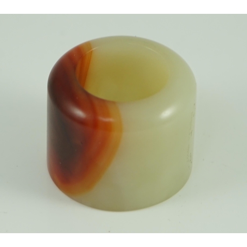 216 - A Chinese pale celadon and russet jade archer's ring, early 20th century 3.4 cm diameter