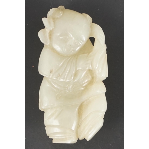 217 - A Chinese celadon jade figure of a boy holding a lotus sprig, 19th century 5.2 cm high