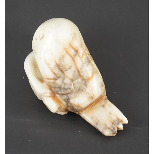 225 - A Chinese white and black jade figure of a preening duck, Ming dynasty, carved in relief with a spri... 