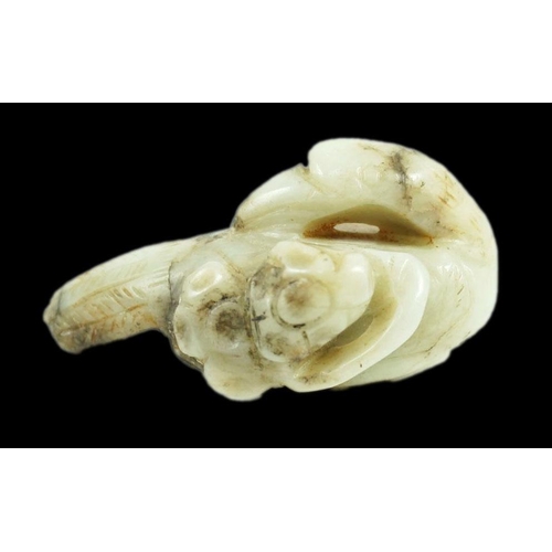 225 - A Chinese white and black jade figure of a preening duck, Ming dynasty, carved in relief with a spri... 