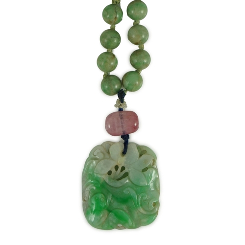 230 - A Chinese jadeite pendant and jadeite beads, 19th century, the pendant carved in relief with a frog ... 