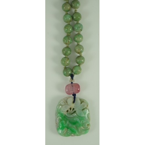 230 - A Chinese jadeite pendant and jadeite beads, 19th century, the pendant carved in relief with a frog ... 