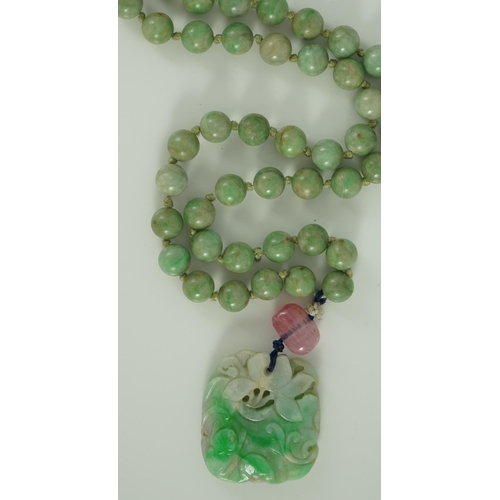 230 - A Chinese jadeite pendant and jadeite beads, 19th century, the pendant carved in relief with a frog ... 