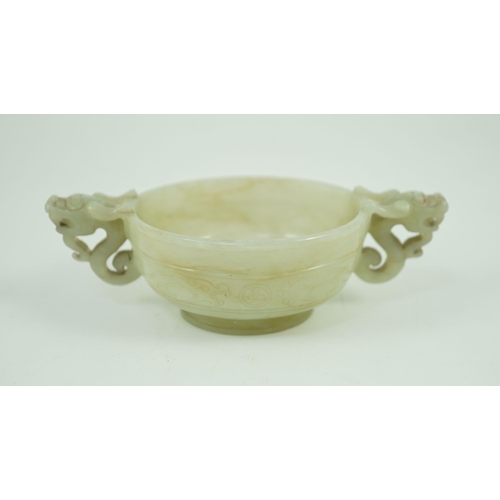 231 - A Chinese pale celadon jade two handled chilong cup, 17th/18th century, with a pair of carved drag... 