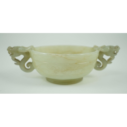 231 - A Chinese pale celadon jade two handled chilong cup, 17th/18th century, with a pair of carved drag... 