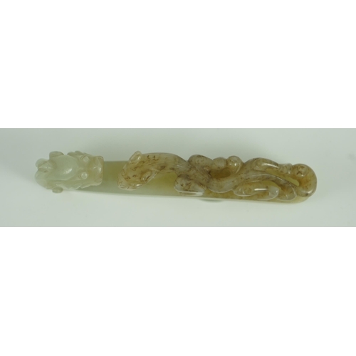 239 - A Chinese pale celadon and brown jade dragon belt hook, 18th/19th century 10.7 cm long