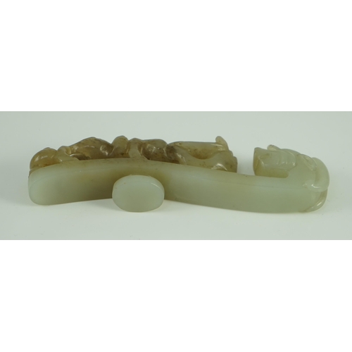 239 - A Chinese pale celadon and brown jade dragon belt hook, 18th/19th century 10.7 cm long