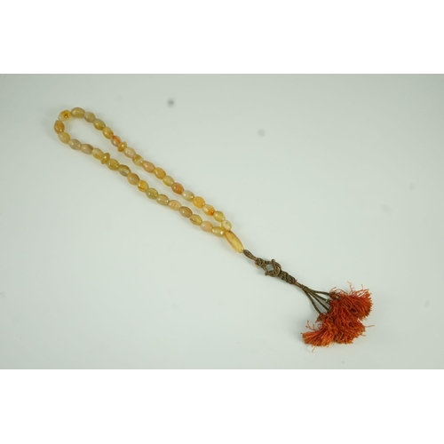 240 - A Sino-Tibetan row of agate prayer beads, 19th century Total drop including tassel 36 cm