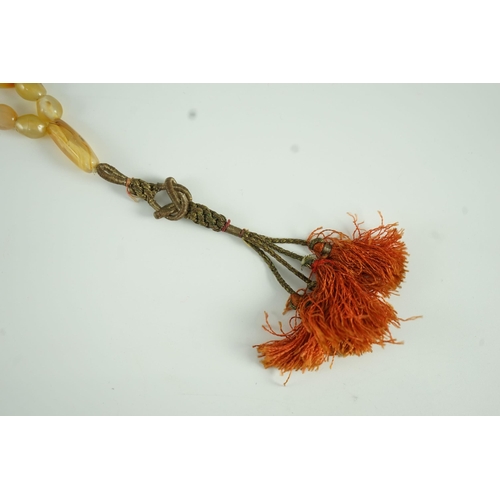 240 - A Sino-Tibetan row of agate prayer beads, 19th century Total drop including tassel 36 cm