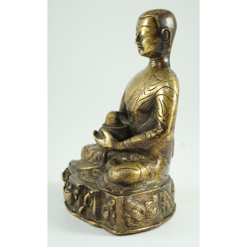 259 - A Himalayan bronze figure of Buddha, 19th century, the seated figure holding an alms bowl, the shape... 