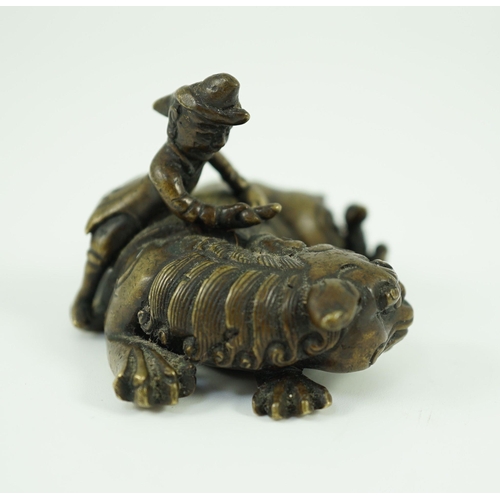 262 - A Chinese bronze Buddhist lion scroll weight, 17th/18th century, cast as a recumbent caparisoned l... 