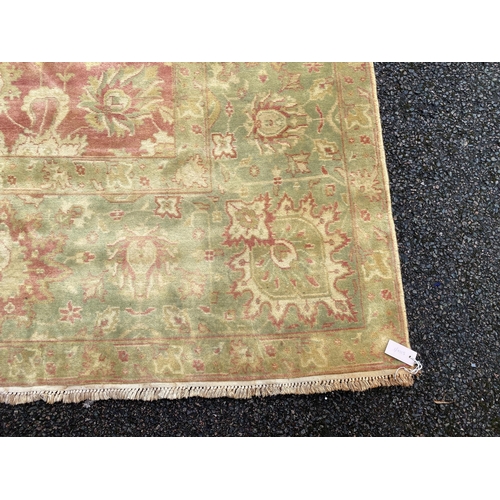 294 - An Indian Agra carpet, with central field of stylised floral motifs on a red ground within a triple ... 