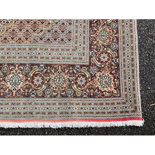 295 - A Persian part silk Tabriz carpet, with central hexagonal motifs on a pink and cream ground, multi-b... 