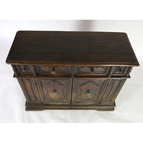 303 - A 17th century Tuscan walnut credenza, the rectangular moulded top, over a pair of shaped oval field... 