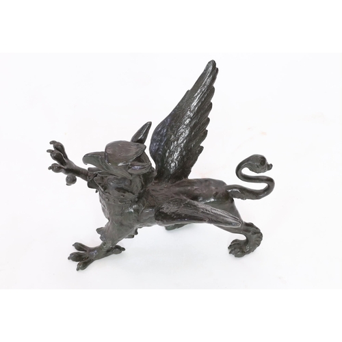 69 - A 19th century bronze model of a griffon, standing with raised paw, length 58cm, height 45cm