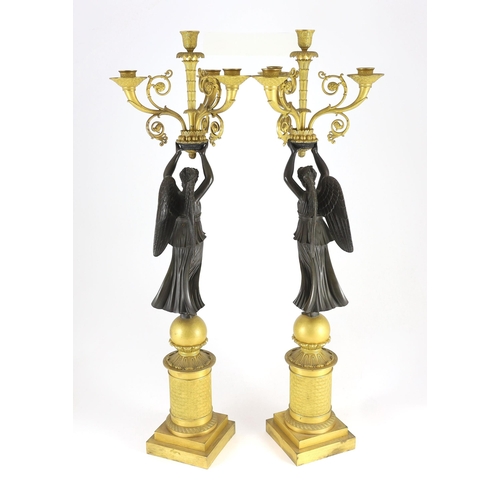 70 - A pair of 19th century French Empire style bronze and ormolu four light candelabra, each with female... 