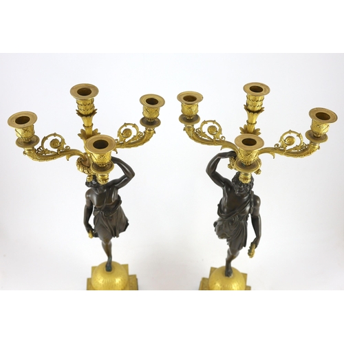 71 - A pair of 19th century French Empire style bronze and ormolu four light candelabra, each modelled wi... 