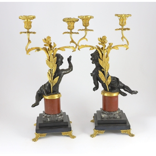 72 - A pair of Louis XVI style bronze and ormolu two light candelabra, each with seated putto stem and sc... 